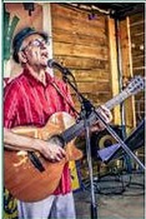 Francis Weill chante avec sa guitare